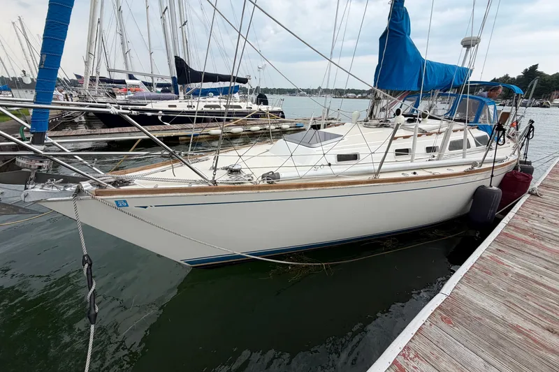 Slide: The Image of 1990 Sabre 34 MK II sailboat docked at marina, featuring blue sail cover. - 6