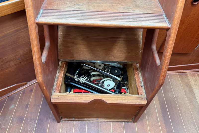 Slide: The Image of Wooden storage compartment on a 1990 Sabre 34 MK II sailboat, containing nautical tools. - 63