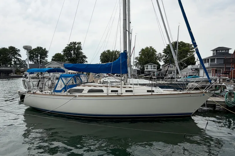 Slide: The Image of 1990 Sabre 34 MK II sailboat docked at a marina with blue covers. - 2