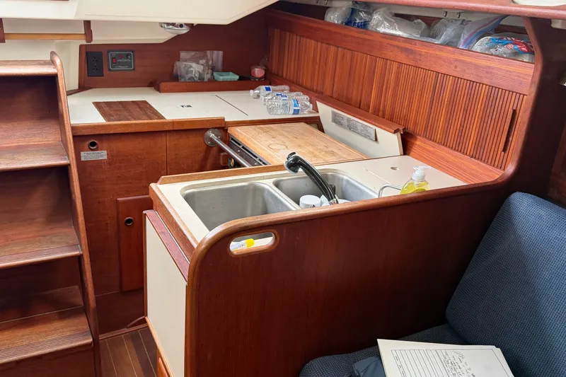 Slide: The Image of Interior of 1990 Sabre 34 MK II sailboat with wooden cabinetry and compact kitchen area. - 29