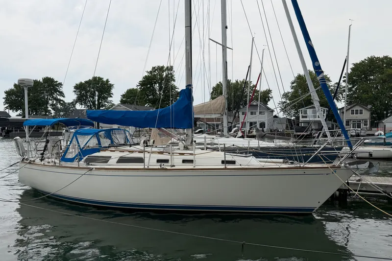 The Image of 1990 Sabre 34 MK II sailboat docked at marina with blue covers and calm water. - 1