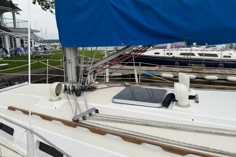 Slide: The Image of 1990 Sabre 34 MK II sailboat docked, featuring blue sail cover and deck details. - 9