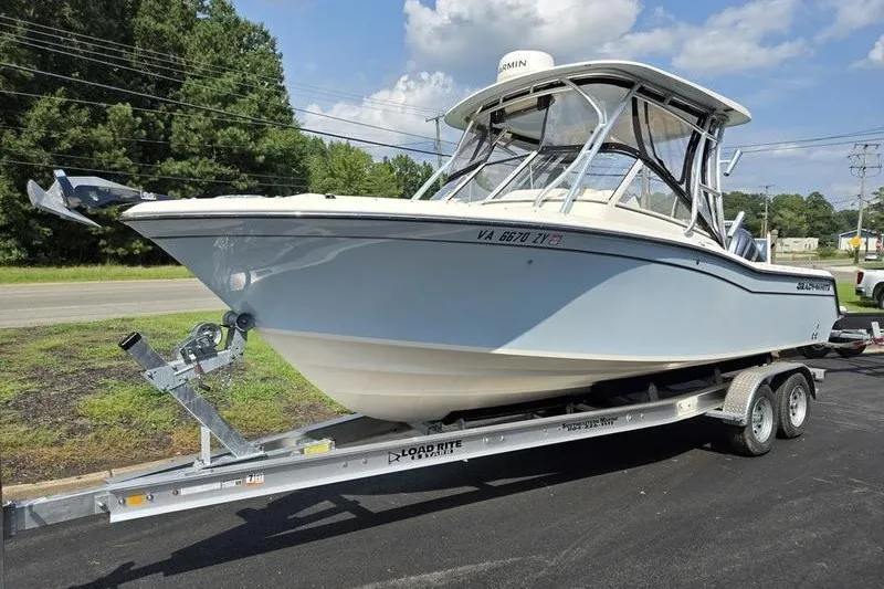 The Image of 2022 Grady-White Freedom 235 boat on trailer, parked outdoors under a clear sky. - 1