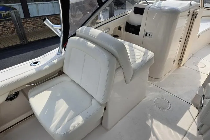 Slide: The Image of 2022 Grady-White Freedom 235 boat interior with white seating and helm area. - 16