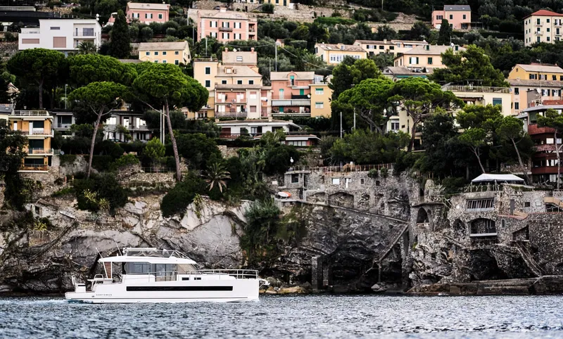 Slide: The Image of Yacht Northman 1300 (2025) cruising near scenic coastal village with colorful hillside houses. - 9