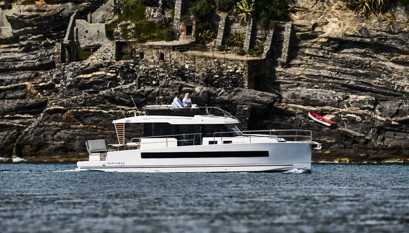 Slide: The Image of 2025 Northman 1300 yacht cruising near rocky shoreline. - 15