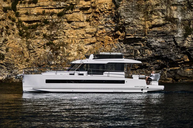 Slide: The Image of 2025 Northman 1300 yacht cruising near rocky cliffs. - 22