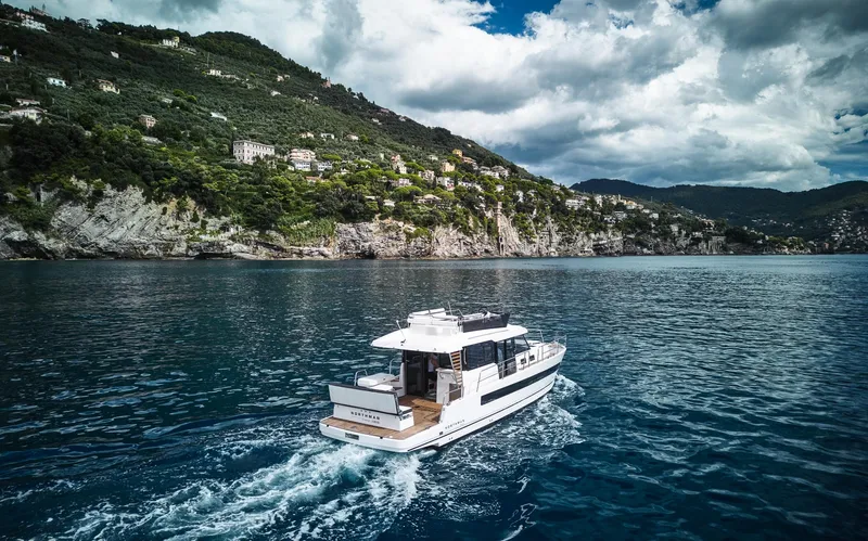Slide: The Image of Luxury Northman 1300 yacht cruising near scenic coastline, 2025 model. - 16