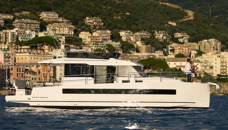 Slide: The Image of 2025 Northman 1300 yacht cruising near scenic coastal town. - 3