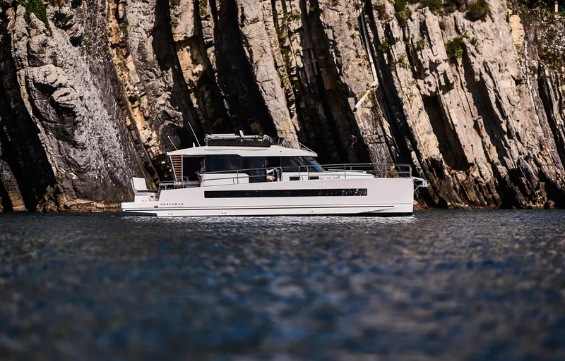 Slide: The Image of 2025 Northman 1300 yacht cruising near rocky cliffs. - 21