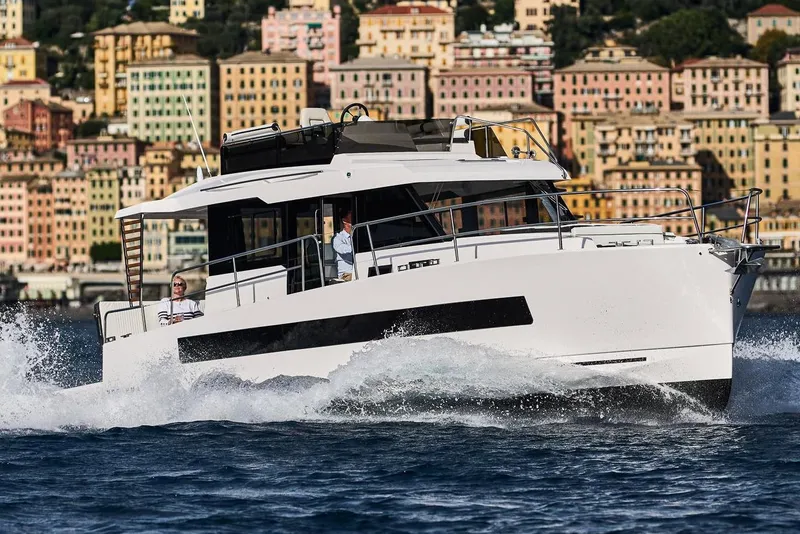 Slide: The Image of 2025 Northman 1300 yacht cruising near colorful coastal buildings. - 1