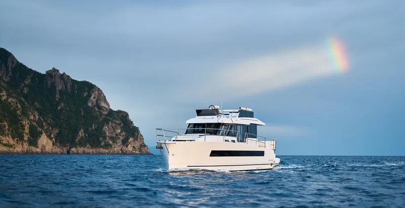 Slide: The Image of Luxury Northman 1300 yacht cruising near cliffs under a rainbow, 2025 model. - 32