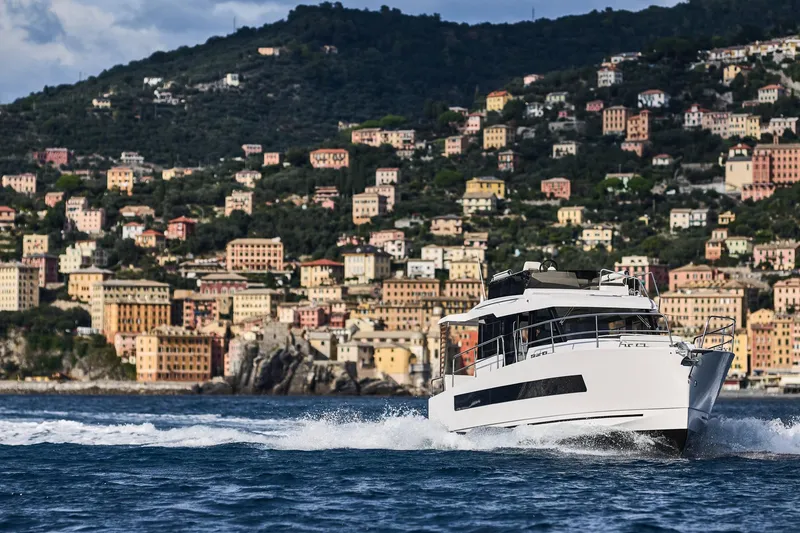 Slide: The Image of 2025 Northman 1300 yacht cruising near colorful coastal town. - 26