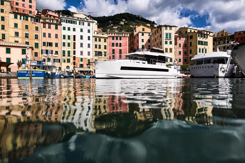 Slide: The Image of Colorful waterfront with boats, including a 2025 Northman 1300, reflecting on calm water. - 20