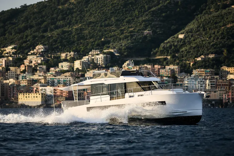 Slide: The Image of 2025 Northman 1300 yacht cruising near coastal city with lush hills. - 6