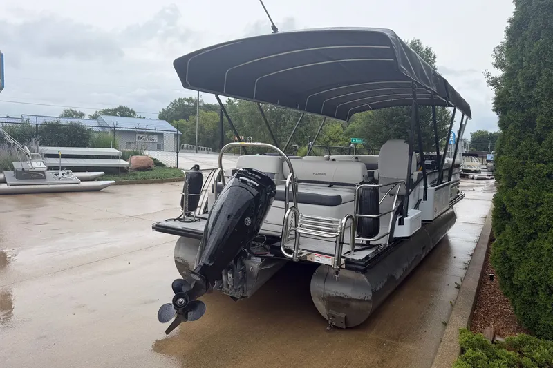 Slide: The Image of 2023 Harris Sunliner 230 pontoon boat with canopy and outboard motor on a wet dock. - 19