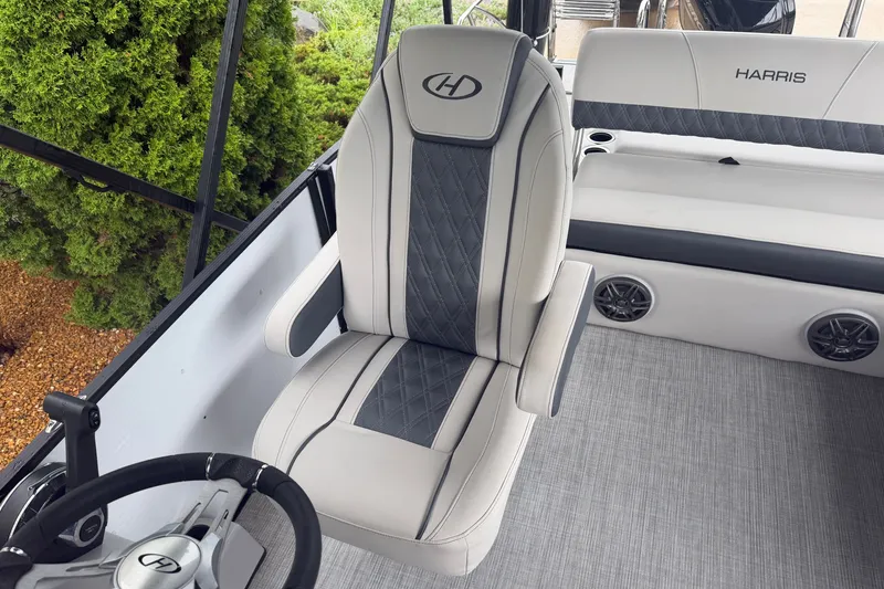 Slide: The Image of 2023 Harris Sunliner 230 boat interior with luxury seating and steering wheel. - 9
