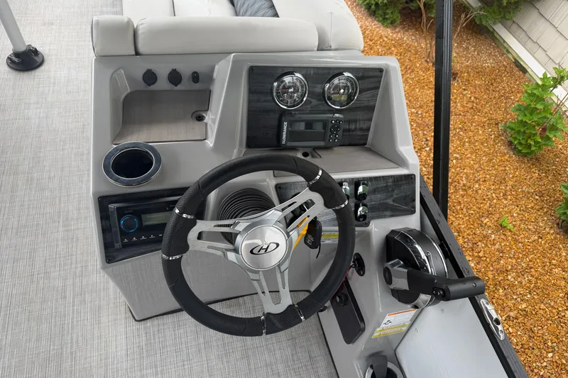 Slide: The Image of 2023 Harris Sunliner 230 boat dashboard with steering wheel and controls. - 10