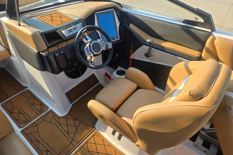 Slide: The Image of 2020 Tigé 23ZX boat interior with tan leather seats and modern dashboard. - 10