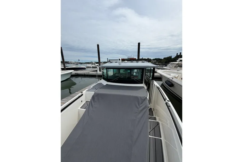 Slide: The Image of 2025 Saxdor 320 GTC boat docked at marina, showcasing sleek design and covered deck. - 14