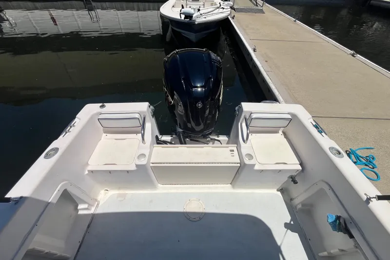 Slide: The Image of 1994 Grady-White Escape 209 boat docked, featuring spacious seating and powerful outboard motor. - 19