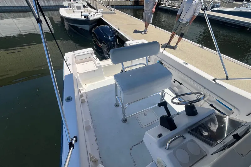 Slide: The Image of 1994 Grady-White Escape 209 boat docked, featuring steering console and seating area. - 15