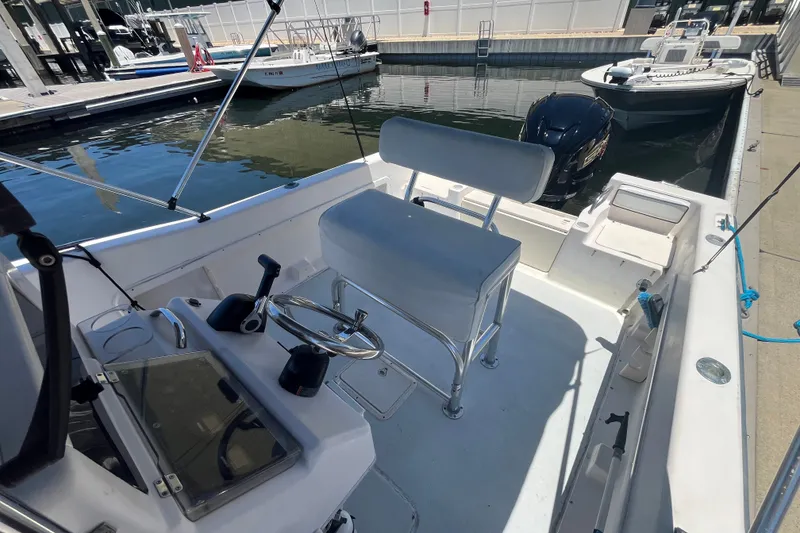 Slide: The Image of 1994 Grady-White Escape 209 boat interior with steering wheel and seating at marina. - 14