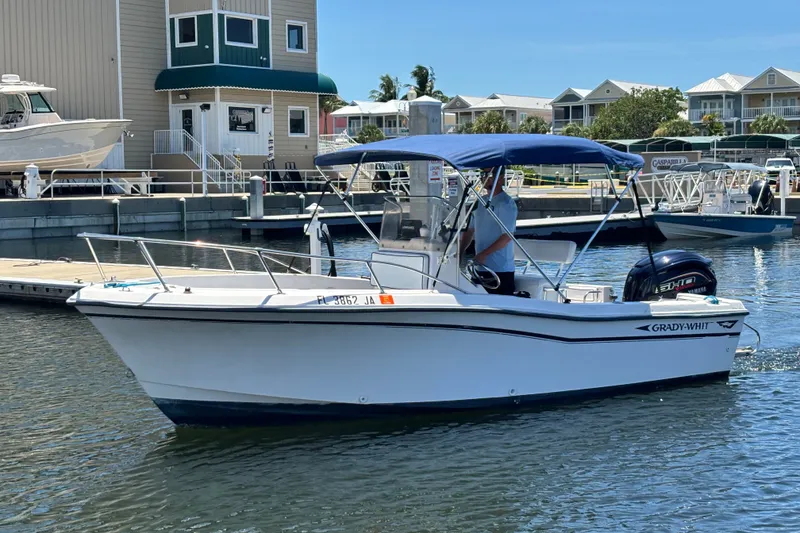 Slide: The Image of 1994 Grady-White Escape 209 boat docked at marina with blue canopy. - 23