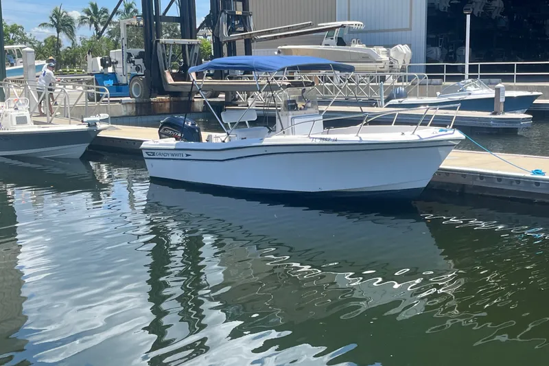 Slide: The Image of 1994 Grady-White Escape 209 boat docked at marina with blue canopy. - 4