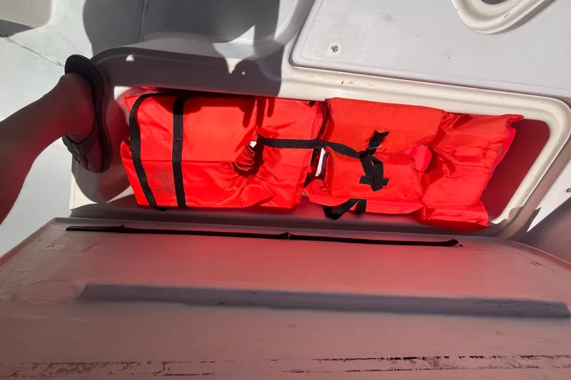 Slide: The Image of Bright orange life jackets stored on a 1994 Grady-White Escape 209 boat. - 25