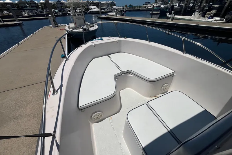 Slide: The Image of 1994 Grady-White Escape 209 boat interior at marina dock, featuring cushioned seating. - 10