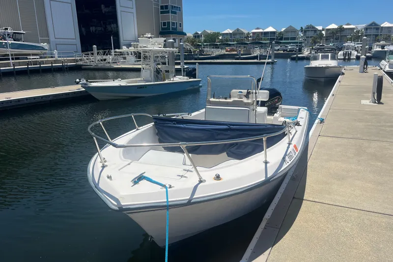 Slide: The Image of 1994 Grady-White Escape 209 boat docked at a marina under clear blue skies. - 22