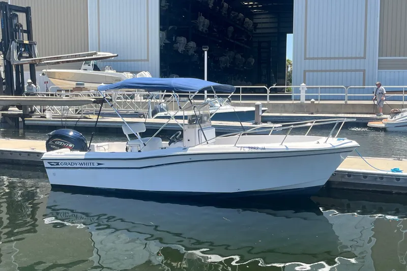 Slide: The Image of 1994 Grady-White Escape 209 boat docked at marina with blue canopy. - 3