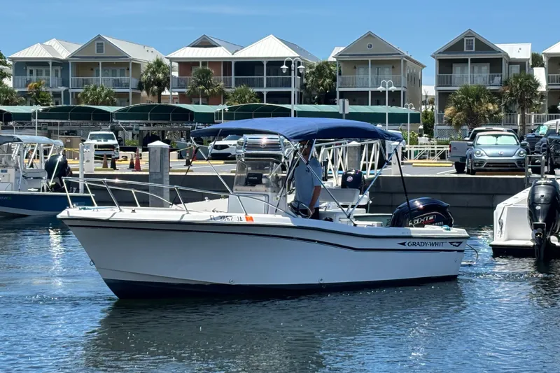 The Image of 1994 Grady-White Escape 209 boat docked at marina with waterfront homes in background. - 1