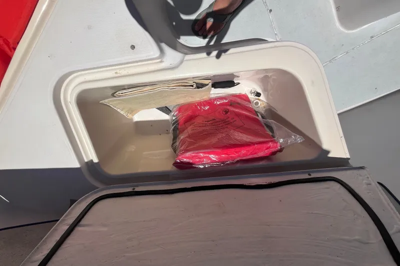 Slide: The Image of Storage compartment on a 1994 Grady-White Escape 209 boat with safety equipment. - 24
