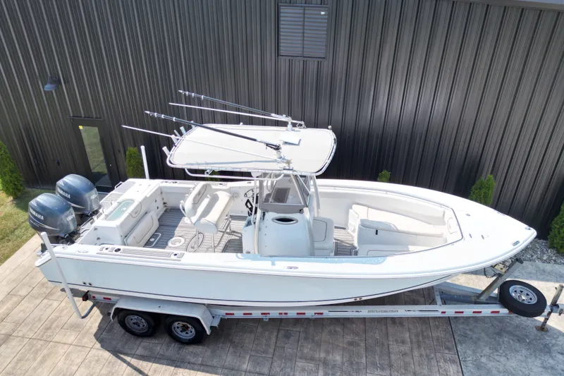Slide: The Image of 2008 Sea Hunt Triton 260 boat on trailer, featuring dual Yamaha engines. - 23