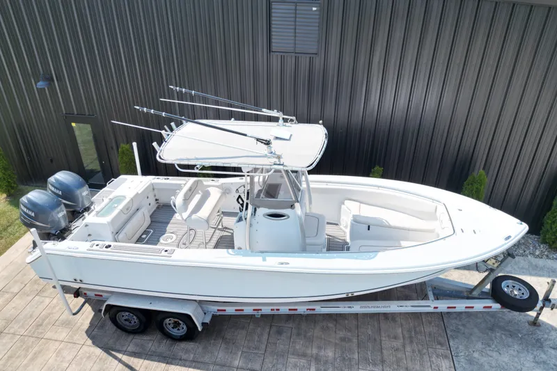 Slide: The Image of 2008 Sea Hunt Triton 260 boat on trailer, featuring dual Yamaha engines. - 22
