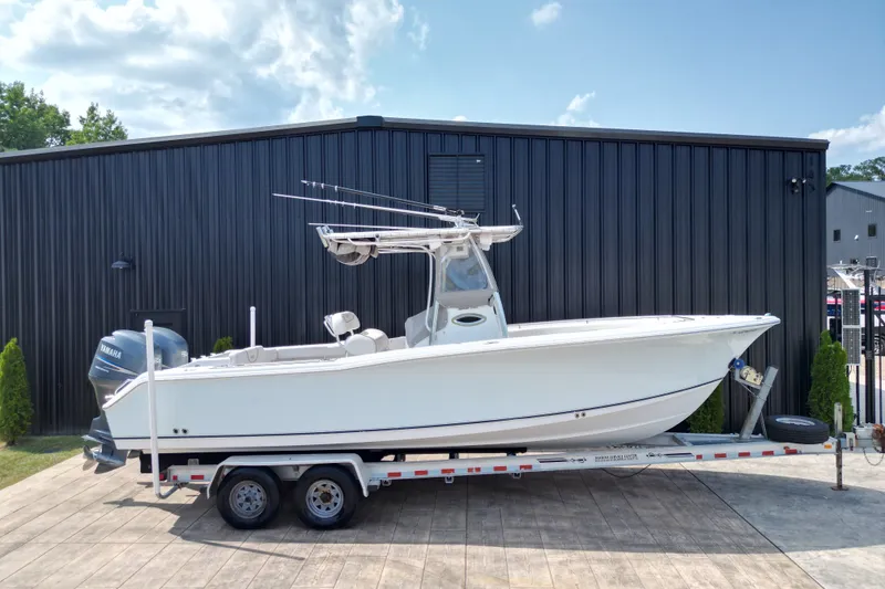 Slide: The Image of 2008 Sea Hunt Triton 260 boat on trailer, parked outside black building. - 2
