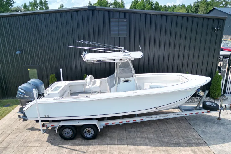 Slide: The Image of 2008 Sea Hunt Triton 260 boat on trailer, parked near a black building. - 29