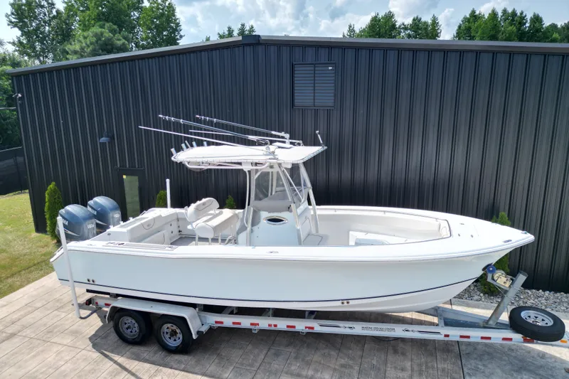 Slide: The Image of 2008 Sea Hunt Triton 260 boat on trailer, parked near a black building. - 31
