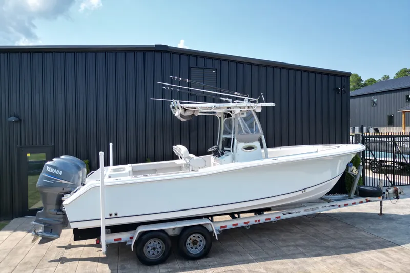 Slide: The Image of 2008 Sea Hunt Triton 260 boat on trailer, parked near black building. - 25