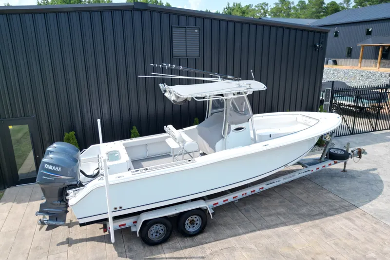 Slide: The Image of 2008 Sea Hunt Triton 260 boat on trailer, parked outside a black building. - 28