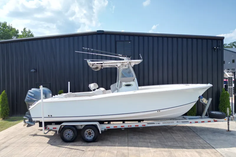 Slide: The Image of 2008 Sea Hunt Triton 260 boat on trailer, parked outside a black building. - 34