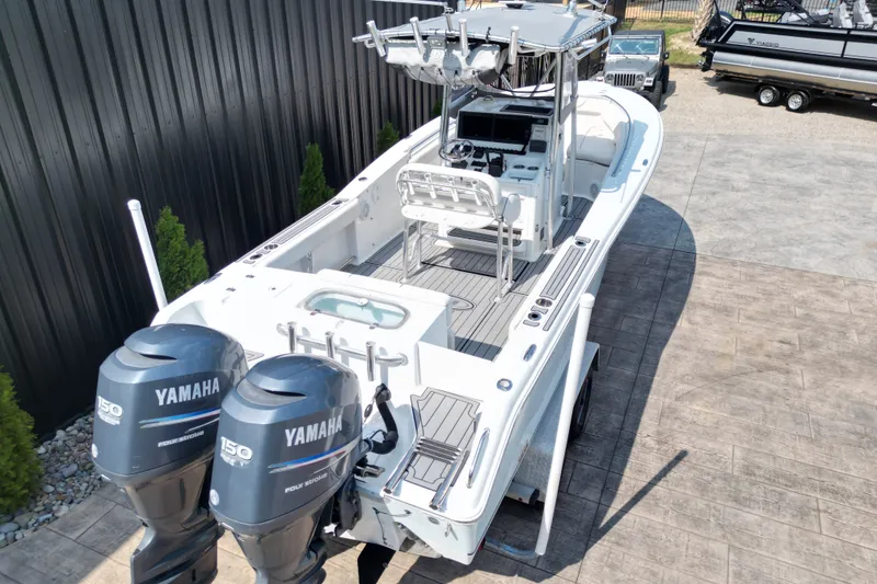 Slide: The Image of 2008 Sea Hunt Triton 260 boat with dual Yamaha engines, docked outdoors. - 17