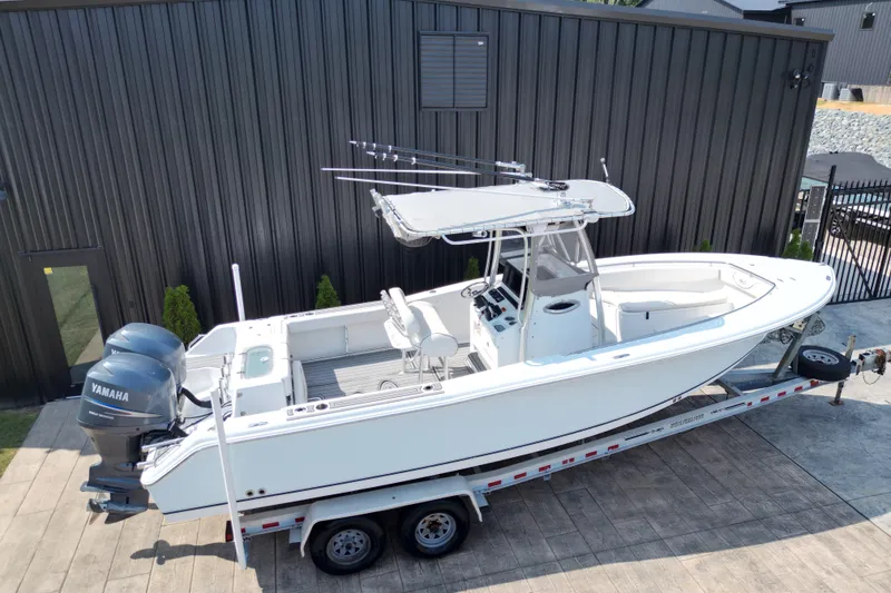 Slide: The Image of 2008 Sea Hunt Triton 260 boat on trailer, featuring dual Yamaha engines. - 19