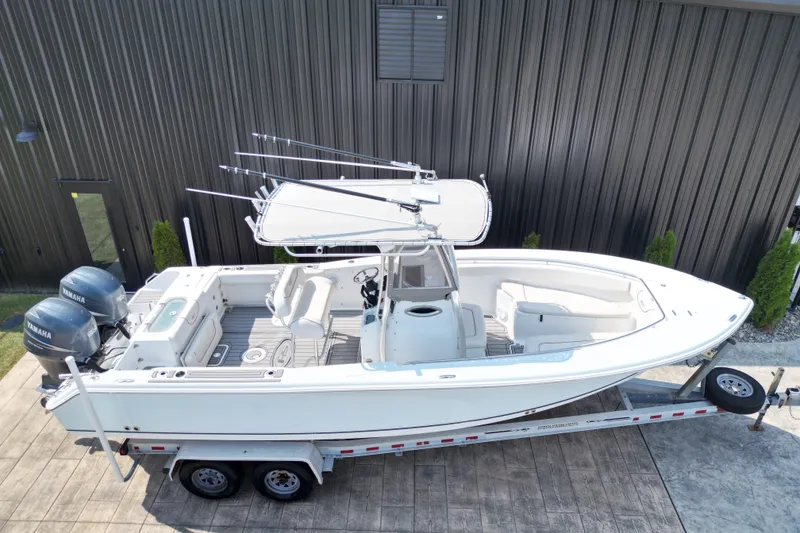 Slide: The Image of 2008 Sea Hunt Triton 260 boat on trailer, featuring dual Yamaha engines. - 24
