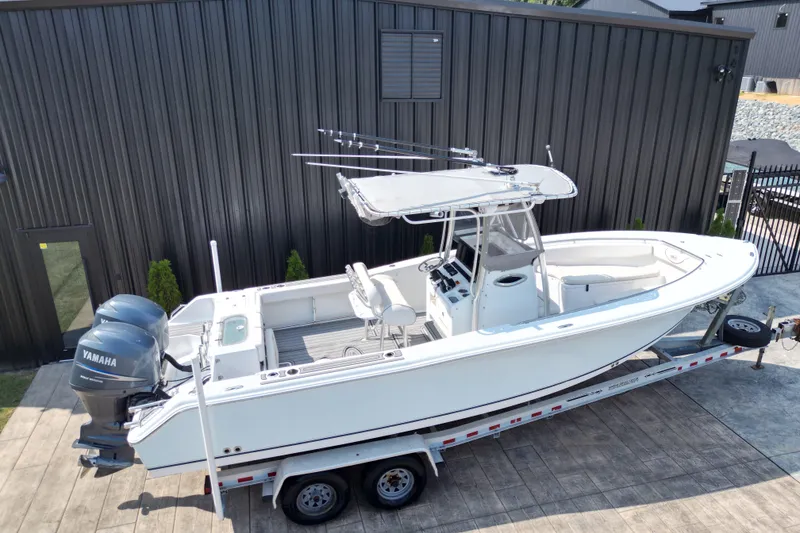 Slide: The Image of 2008 Sea Hunt Triton 260 boat on trailer, featuring dual Yamaha engines. - 20