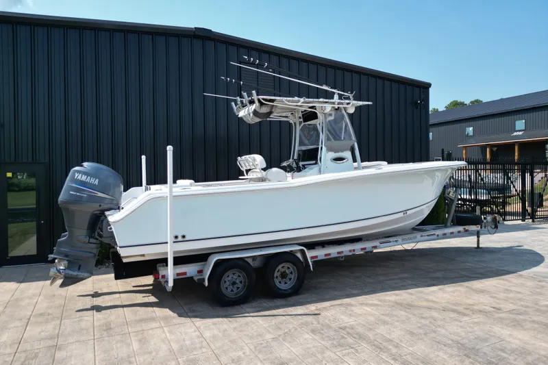 Slide: The Image of 2008 Sea Hunt Triton 260 boat on trailer, parked outside a black building. - 27