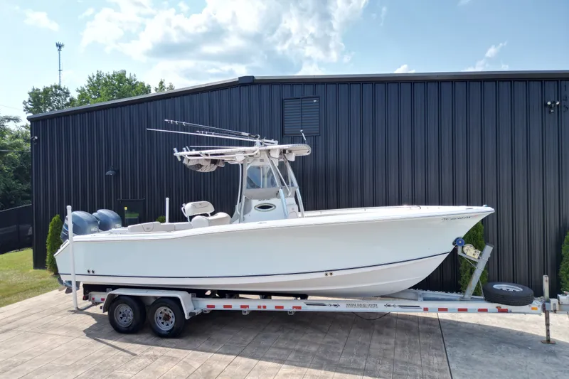 Slide: The Image of 2008 Sea Hunt Triton 260 boat on trailer, parked outdoors near a black building. - 32