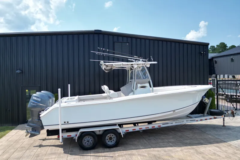 Slide: The Image of 2008 Sea Hunt Triton 260 boat on trailer, parked outside a black building. - 33